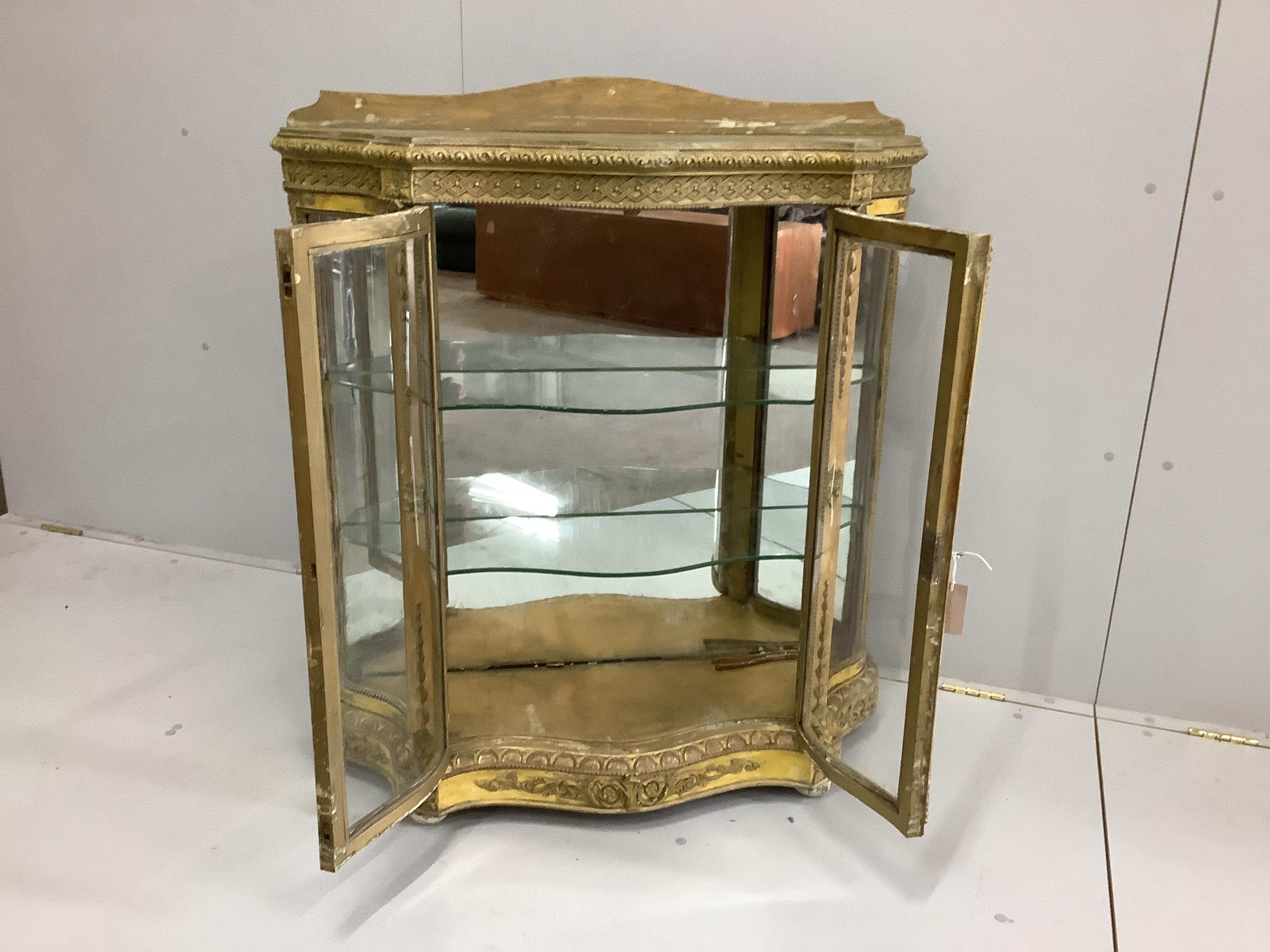 A Victorian giltwood and composition glazed serpentine side cabinet, width 92cm, depth 33cm, height 104cm